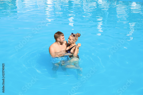 Happy young couple in swimming pool at resort
