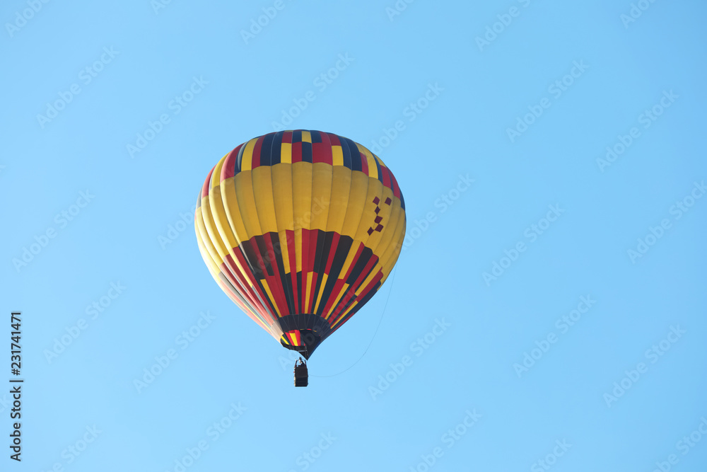 Colorful hot air balloon flying in blue sky. Space for text Colorful hot air balloon flying in blue sky. Space for text