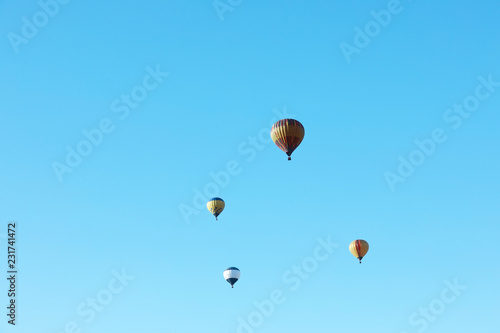 Colorful hot air balloons flying in blue sky. Space for text