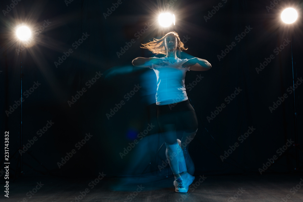People and dancing concept - young woman dancer jumping on black background