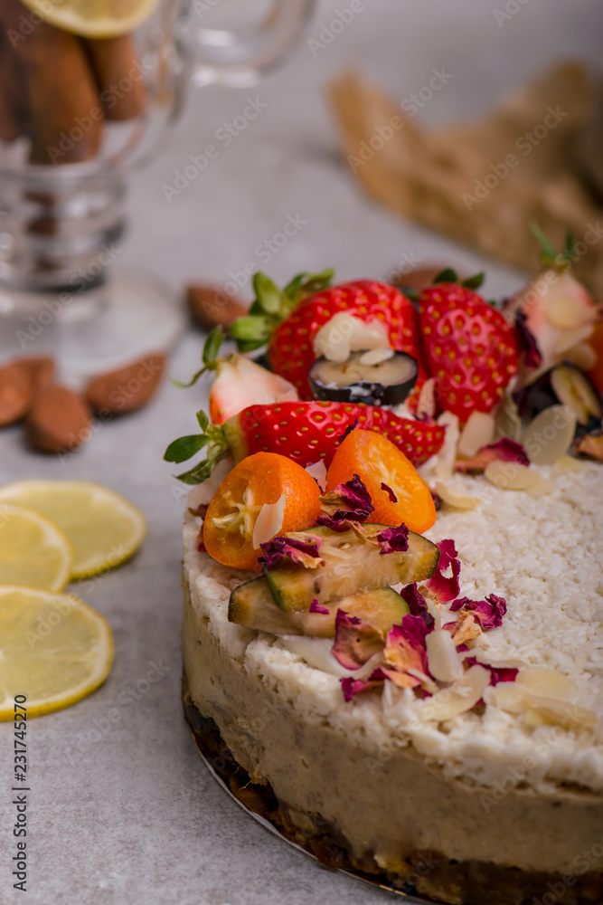 White cake with fruit, berries and almonds on a light background. Piece of cake. White cake with fruit, berries and almonds on a light background. Piece of cake.