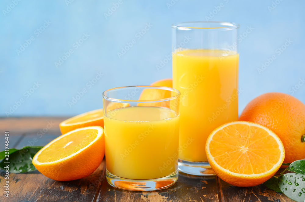 Fresh orange juice in a glasses on old wooden table, selective focus. Fresh orange juice in a glasses on old wooden table, selective focus.