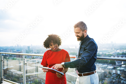 Photography A portrait of two businesspeople standing against London view panorama