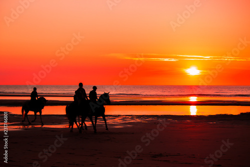 Reiter auf Pferden  im Sonnenuntergang  am Strand  an der Nordsee am Meer