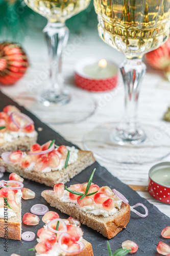 Mini sandwiches with feta cheese, pomegranates, red onions and rosemary. Holiday appetizers to wine for gourmets. New year. Christmas