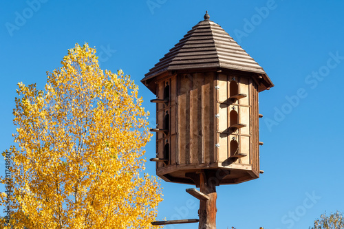Tableau sur toile The wooden dovecote on the background of the blue sky