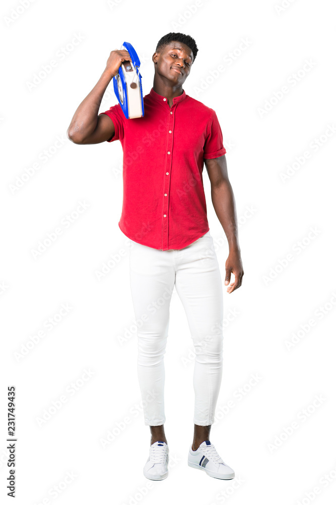 Full body of Young african american man holding a blue vintage radio on white background Full body of Young african american man holding a blue vintage radio on white background