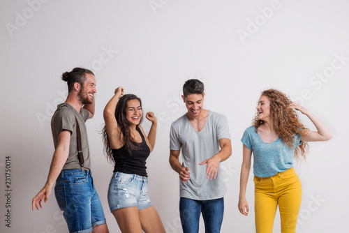 Portrait of joyful young friends dancing in a studio.