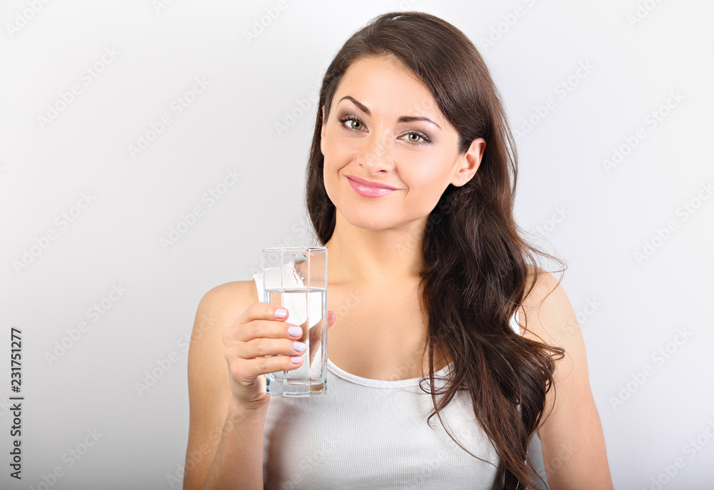 Calm happy woman with healthy skin and long curly hair drinking pure water on blue background. Closeup Calm happy woman with healthy skin and long curly hair drinking pure water on blue background. Closeup