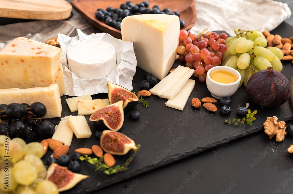 Cheese plate served with grapes, jam, figs Cheese plate served with grapes, jam, figs