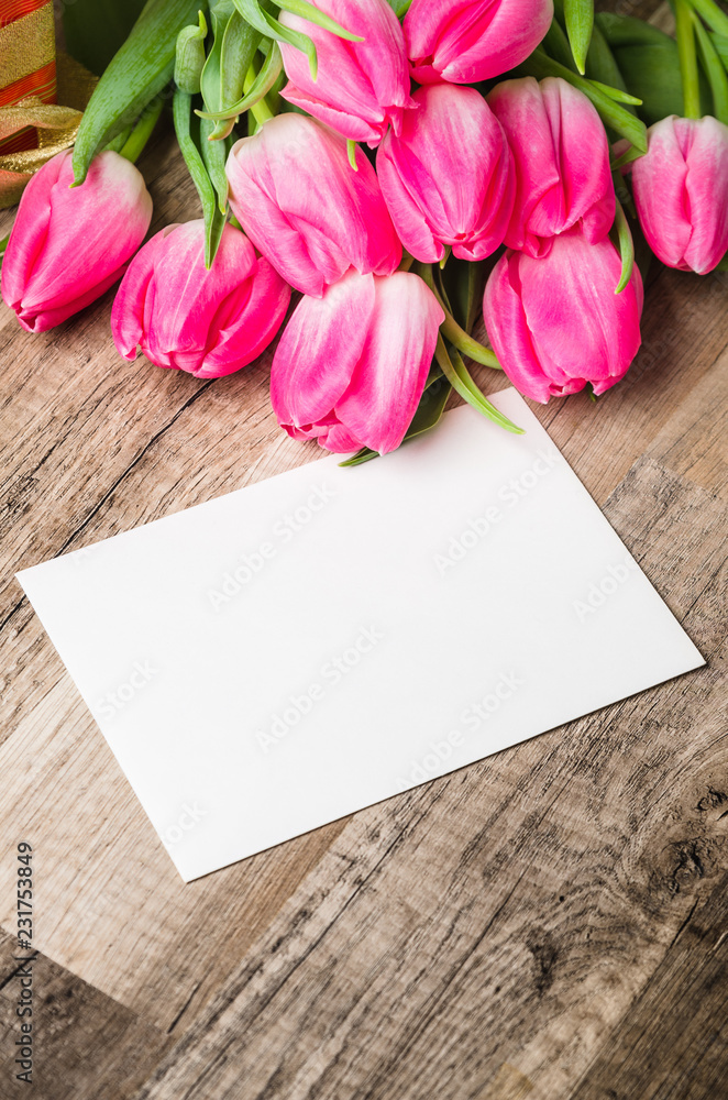 Fototapeta premium Beautiful bouquet of pink tulips and congratulations on the table