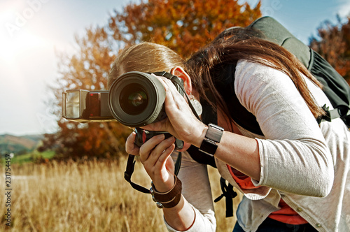 Fotografin mit Kamera in der Abendsonne in der Natur
