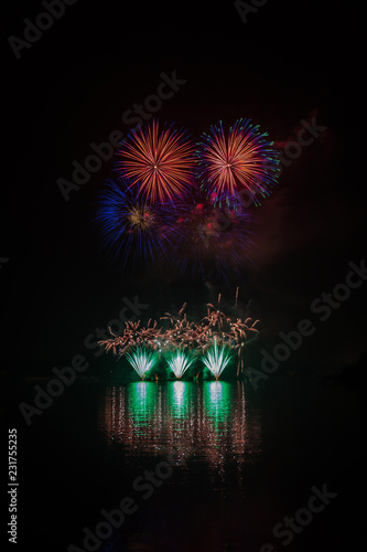 Huge, rich and colorful fireworks over surface of Brno's Dam with reflection on the surface of lake photo