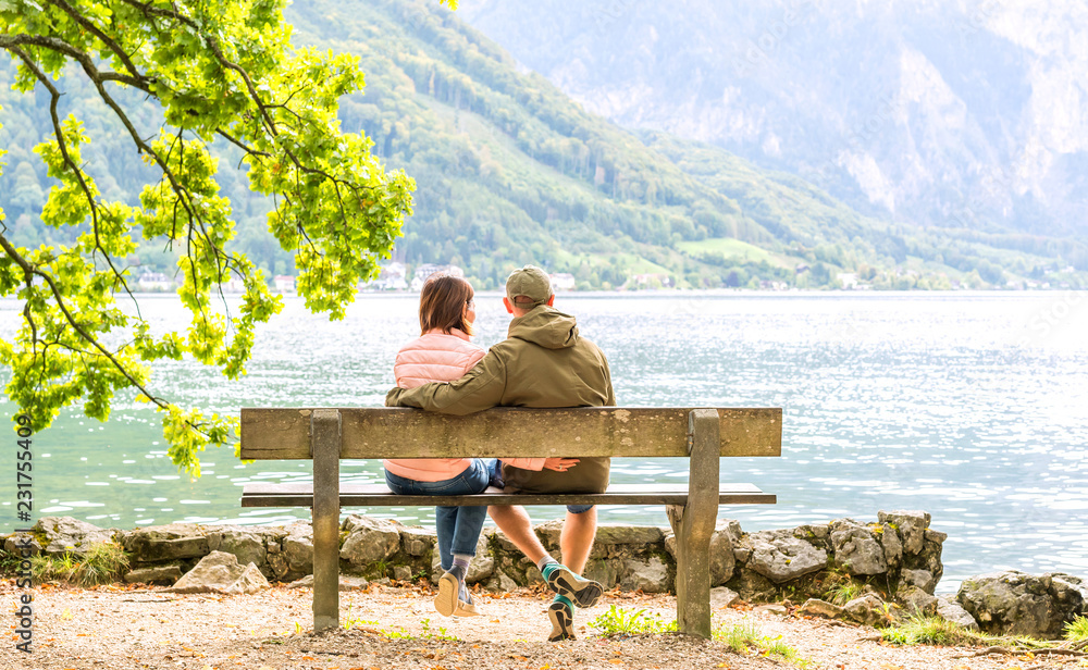 Happy couple sitting on the wooden bench