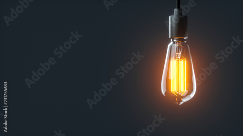 Eine einzelne leuchtende Edison Glühlampe hängt in einem dunklen Raum von der Decke