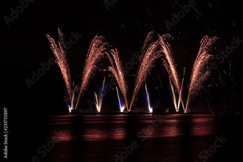 Big crackling explosion in rich fireworks over Brno's Dam with lake reflection photo