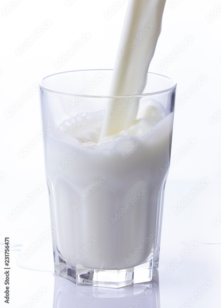 pouring a glass of milk creating splash on a white background pouring a glass of milk creating splash on a white background