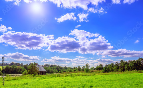 Vibrant wide angle view of a summer countryside landscape and blue cloudy sky