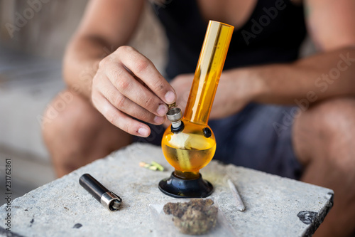 Man filling up bong with cannabis