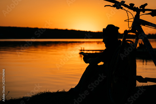 The guy rests on the river bank.