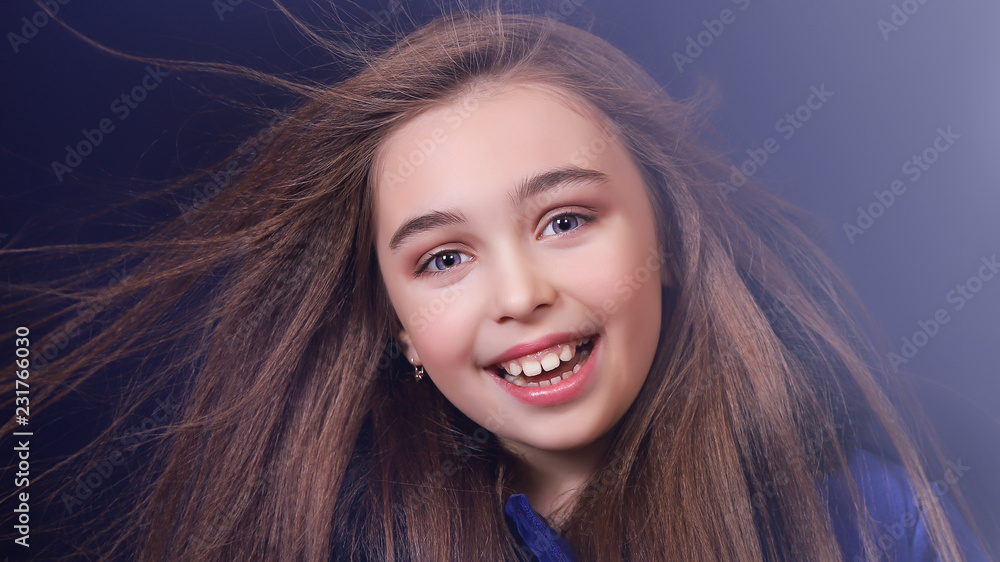 Fototapeta premium Портрет красивой девушки в пальто, дует ветер, разлетаются длинные волосы