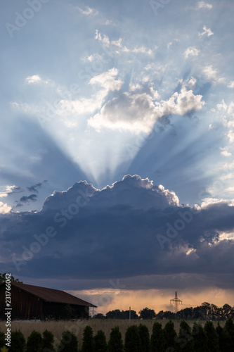 Changing Weather with Sunbeams above Field with Hut, Germany. photo