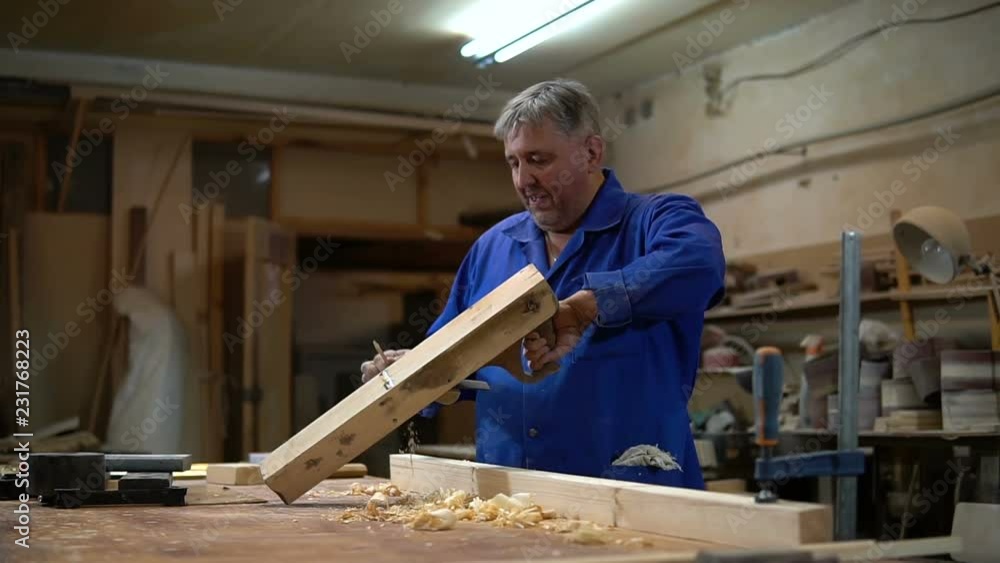 carpenter working in the Studio, worker planing a tree with a planer carpenter working in the Studio, worker planing a tree with a planer