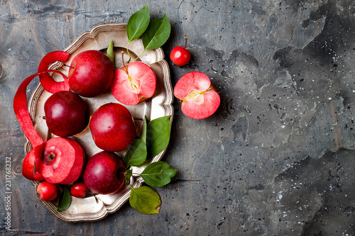 Still life with apples on vintage plate over gray table, top view. Fresh red apples Baya Marisa with leaves. photo