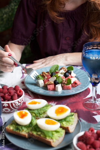 Fototapeta Naklejka Na Ścianę i Meble -  A light summer dinner for two: salad, boiled eggs, raspberries for dessert and white wine.