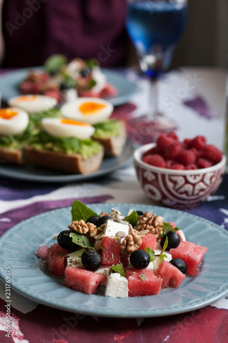 A light summer dinner for two  salad  boiled eggs  raspberries for dessert and white wine.