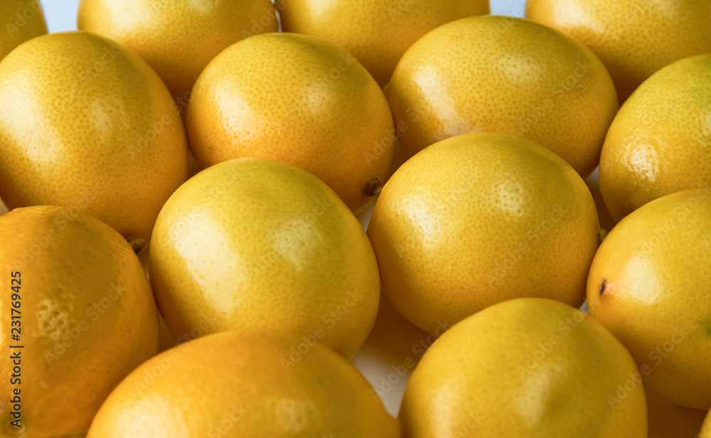 Ripe yellow lemons on white background, texture, close-up. Ripe yellow lemons on white background, texture, close-up.