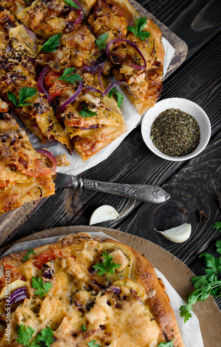 Delicious and appetizing pizza from yeast dough. Delicious and healthy vegetable pizza. Vegetable pizza on a black wooden table. photo