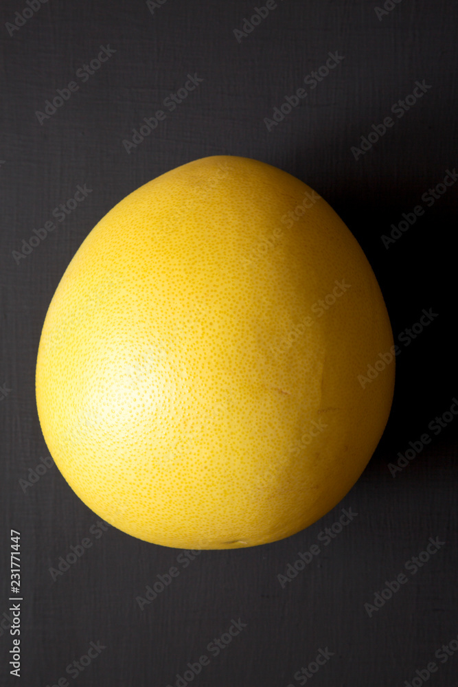 Fresh pomelo citrus on black background, top view. Closeup. Fresh pomelo citrus on black background, top view. Closeup.
