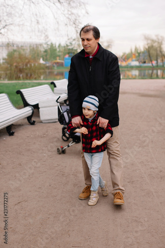 Father helping to walk to his son with infant cerebral paralysis photo