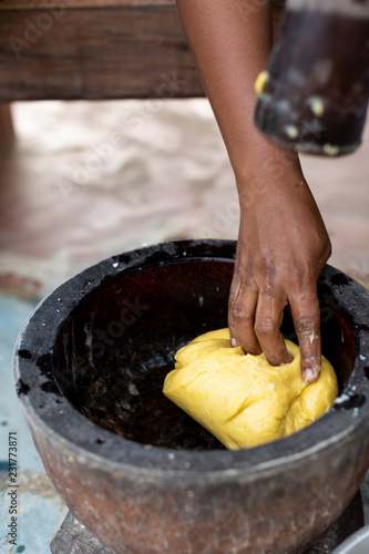 Person using a mortar and pestle to mix dough as part of a meal