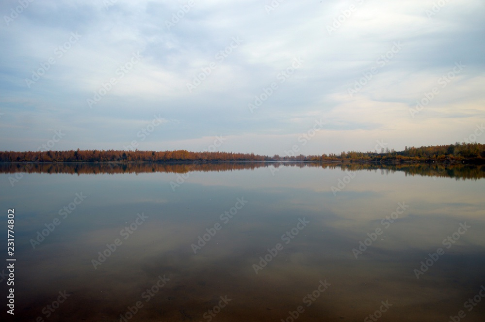 Morning mood in autumn on the water with fog, lake with waves and trees on the shore,