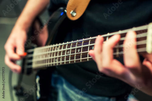 Hands the bass player. Closeup. Playing the guitar. Selective fo