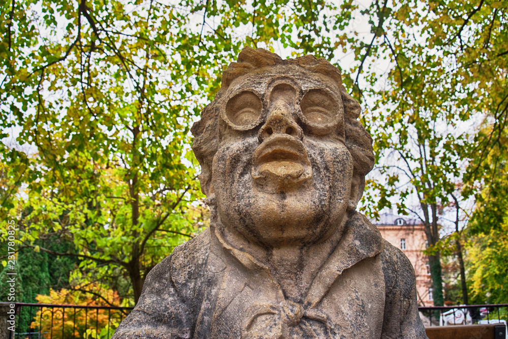 Stone statue of a dwarf. Marble sculpture of fairy gnome in Salzburg Mirabellgarten park, Salzburg, Austria