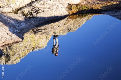 Upside Down Hiker Silhouette Reflected in Still Water of Granite Fissure on Mount Seymour Peak, North Shore Mountains above Vancouver, British Columbia, Canada