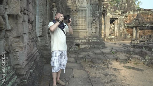 Tourist using camera and doing photos of ancient ruins photo