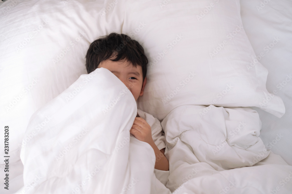 3 years old little cute Asian boy at home on the bed, kid lying playing and smiling on white bed with pillow and blanket, top view with copy space. 3 years old little cute Asian boy at home on the bed, kid lying playing and smiling on white bed with pillow and blanket, top view with copy space.