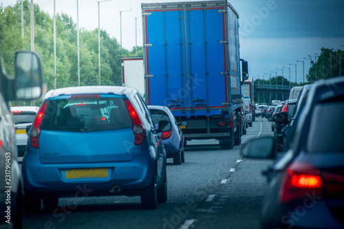 Closeup of busy Highway transportation  motorway full of cars in the evening with dark cloudy blue sky