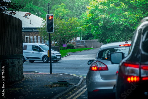Closeup of some Cars stopping in red traffic light while other car coming in a beautiful spring day