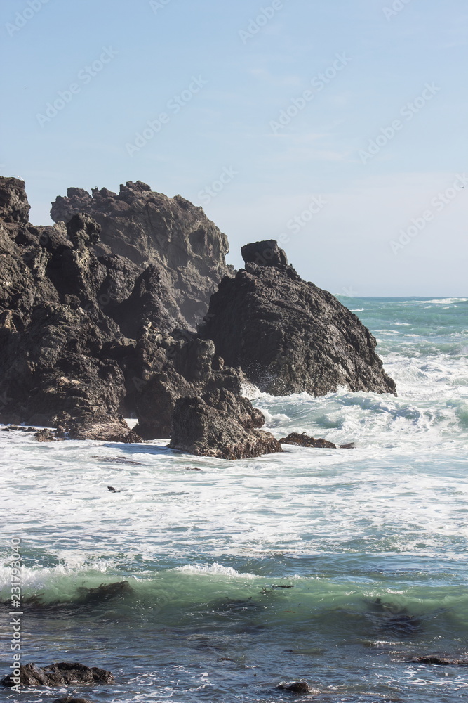 Close up image of waves crashing into rocky outcrops along the Cape Palliser coast of New Zealand.