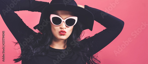 Fashionable woman in sunglasses on a pink background