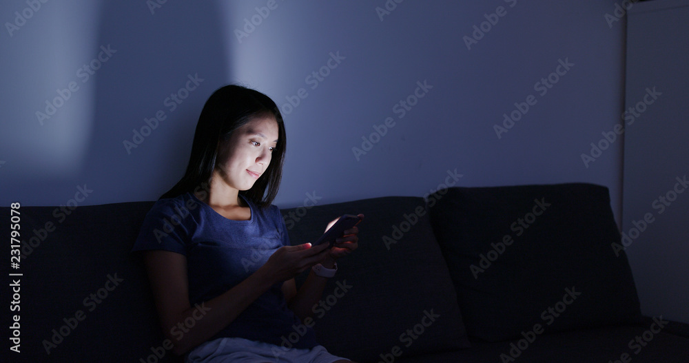 Woman use of mobile phone at home in the evening Woman use of mobile phone at home in the evening