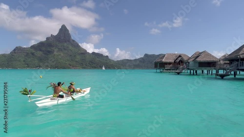 Aerial - Meal delivery to overwater villa in a traditional Polynesian canoe in