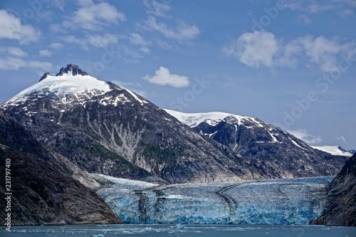 Endicott Arm, Alaska, USA: The Dawes Glacier flows down from snow-capped mountains through a valley at the end of a fjord in the Pacific Northwest. © Linda Harms