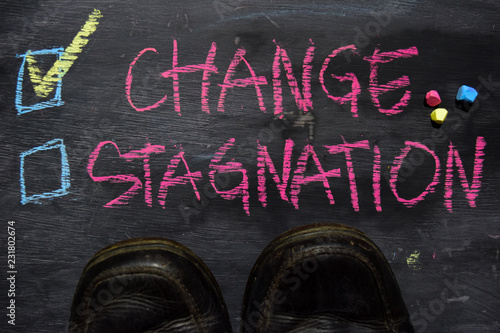 Change or Stagnation written with color chalk concept on the blackboard photo