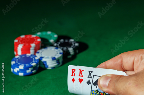 Casino games concept,Poker chips on gamble table , Light through background, winning hands of cards. gambling success